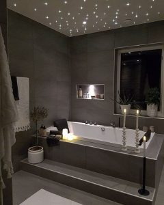 Une salle de bain dans les tons marrons avec une grande baignoire