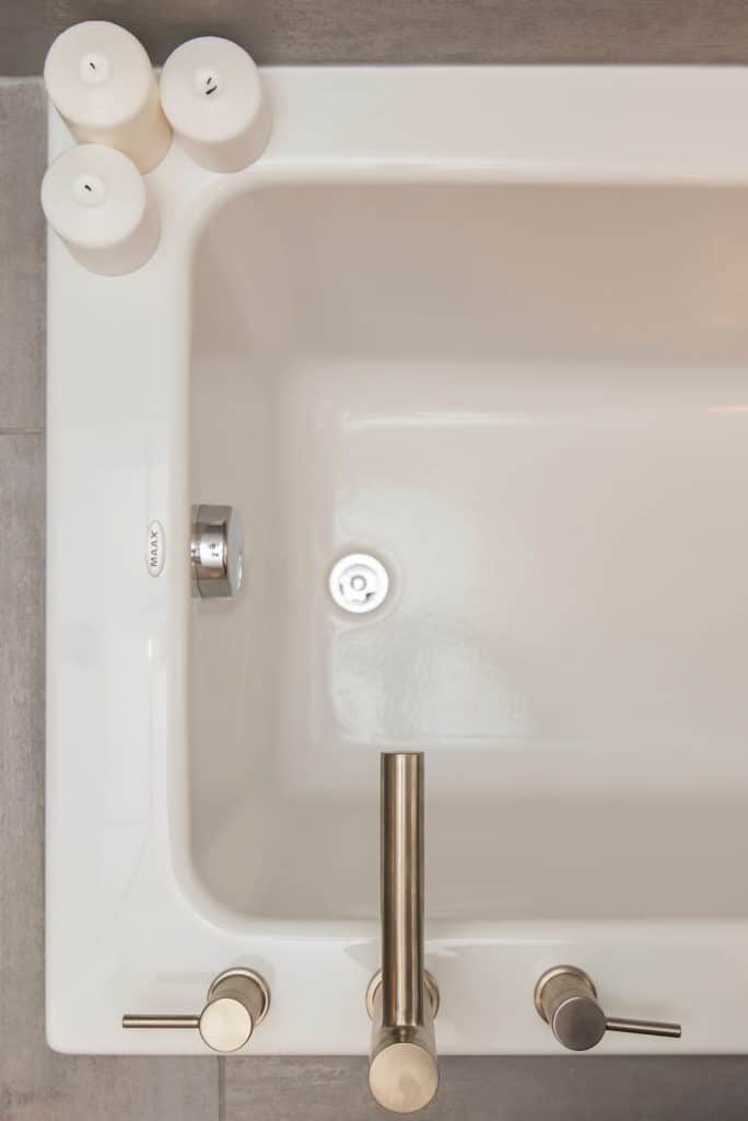 Une baignoire blanche avec un robinet argenté