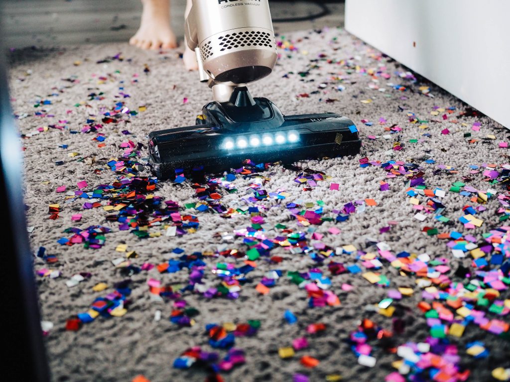 Un aspirateur qui nettoie un tapis recouvert de confettis 